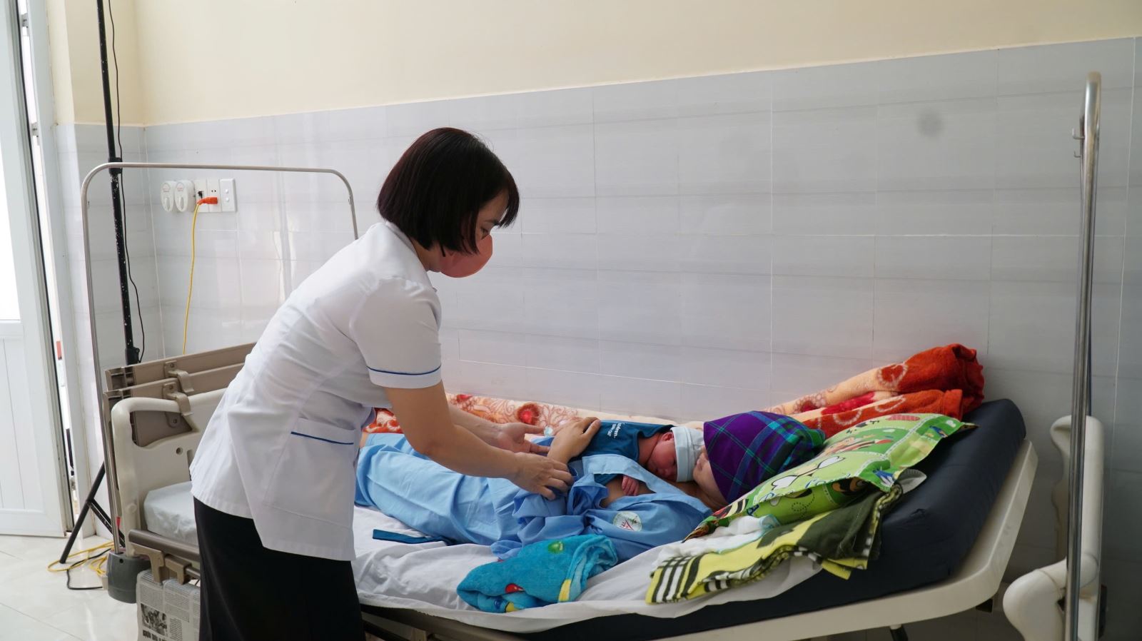 Điều dưỡng viên hướng dẫn sản phụ cách cho con bú sau sinh.