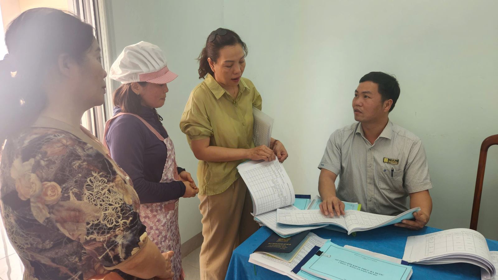 Ông Trần Quang Hưng - Phó Trưởng phòng An toàn thực phẩm, Sở Y tế kiểm tra quá trình ghi chép quản lý thực phẩm hàng ngày tại Trường Mầm non Cư Êbur (phường Buôn Ma Thuột)